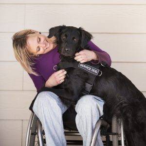 Photo Of The Happy Woman On The Disabled Carriage With A Service Dog