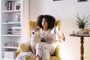 Girl and a dog sit on a yellow chair