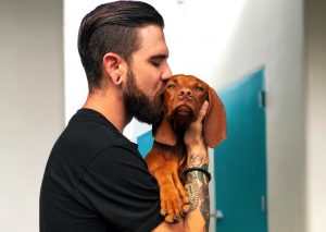 photo of man kissing his dog